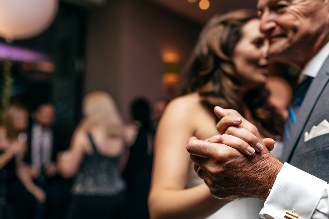 brides-father-holds-hands-during-dancing-london-wedding-devonshire-terrace