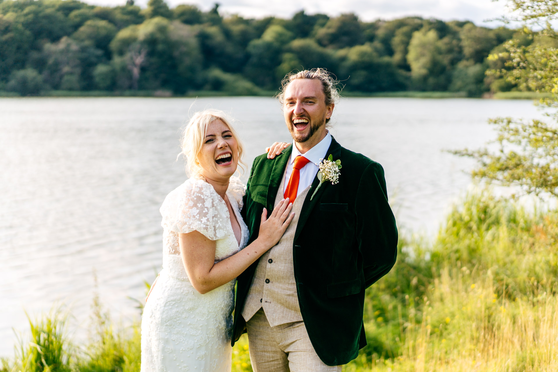 Couple on the banks of the mere at Combermere Abbey in Cheshire on their wedding day 